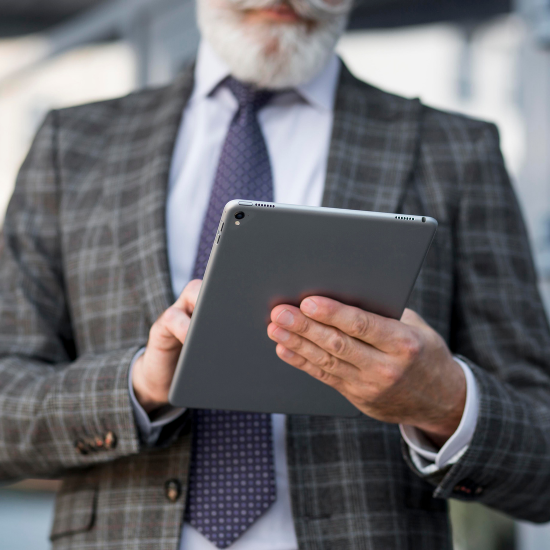 Three real estate agents looking at a tablet screen while standing outside a home